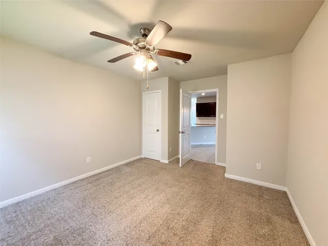 an empty room with closet and a chandelier fan