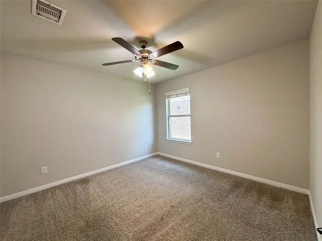 an empty room with a window and a fan