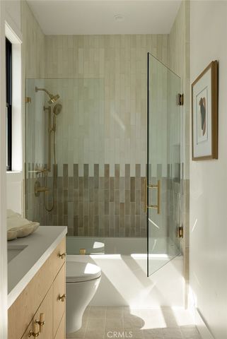 a bathroom with a shower sink mirror and toilet