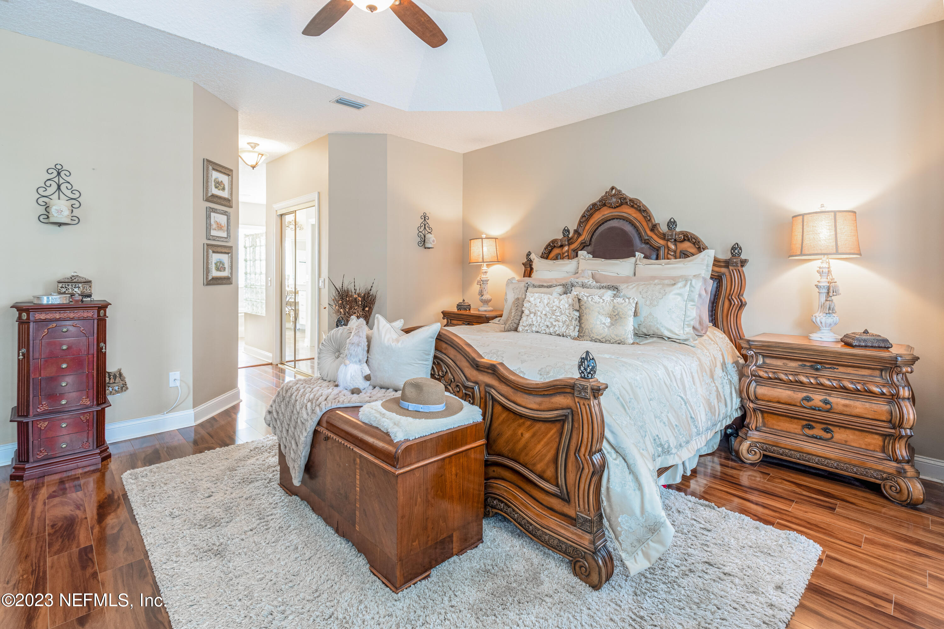 729 Cherry Grove Road Orange Park, FL 32073 - Photo 16 of 47 a spacious bedroom with a bed a couch and a chandelier