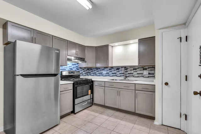 a kitchen with stainless steel appliances granite countertop a refrigerator and a sink