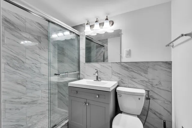 a bathroom with a toilet sink and mirror