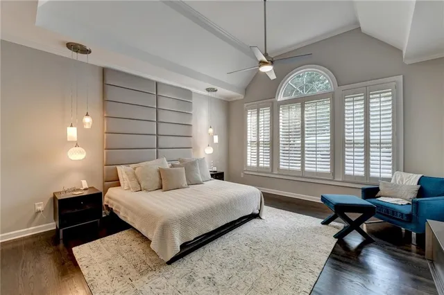 a bedroom with a large bed and a chandelier