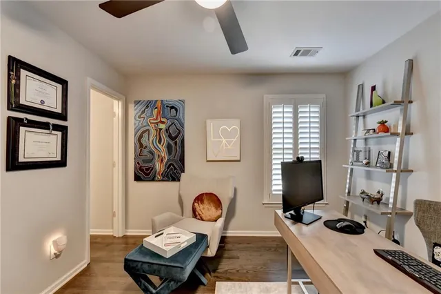 a bedroom with bed and a laptop on the desk