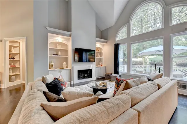 a living room with furniture fireplace and a large window