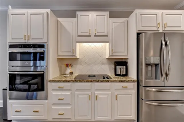 a kitchen with appliances a refrigerator and cabinets