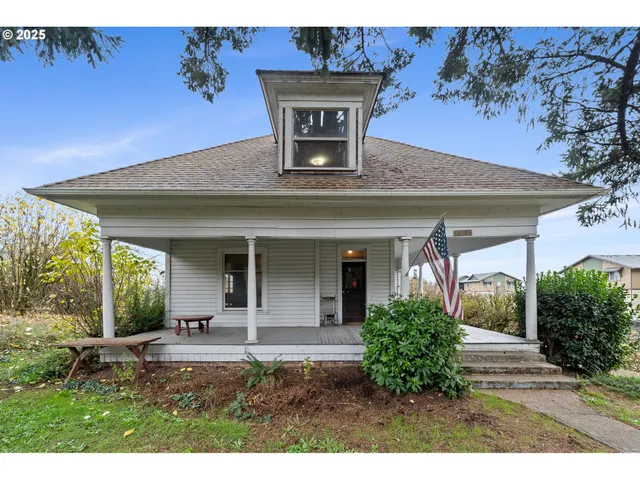 a view of a house with potted plants and a table and chair