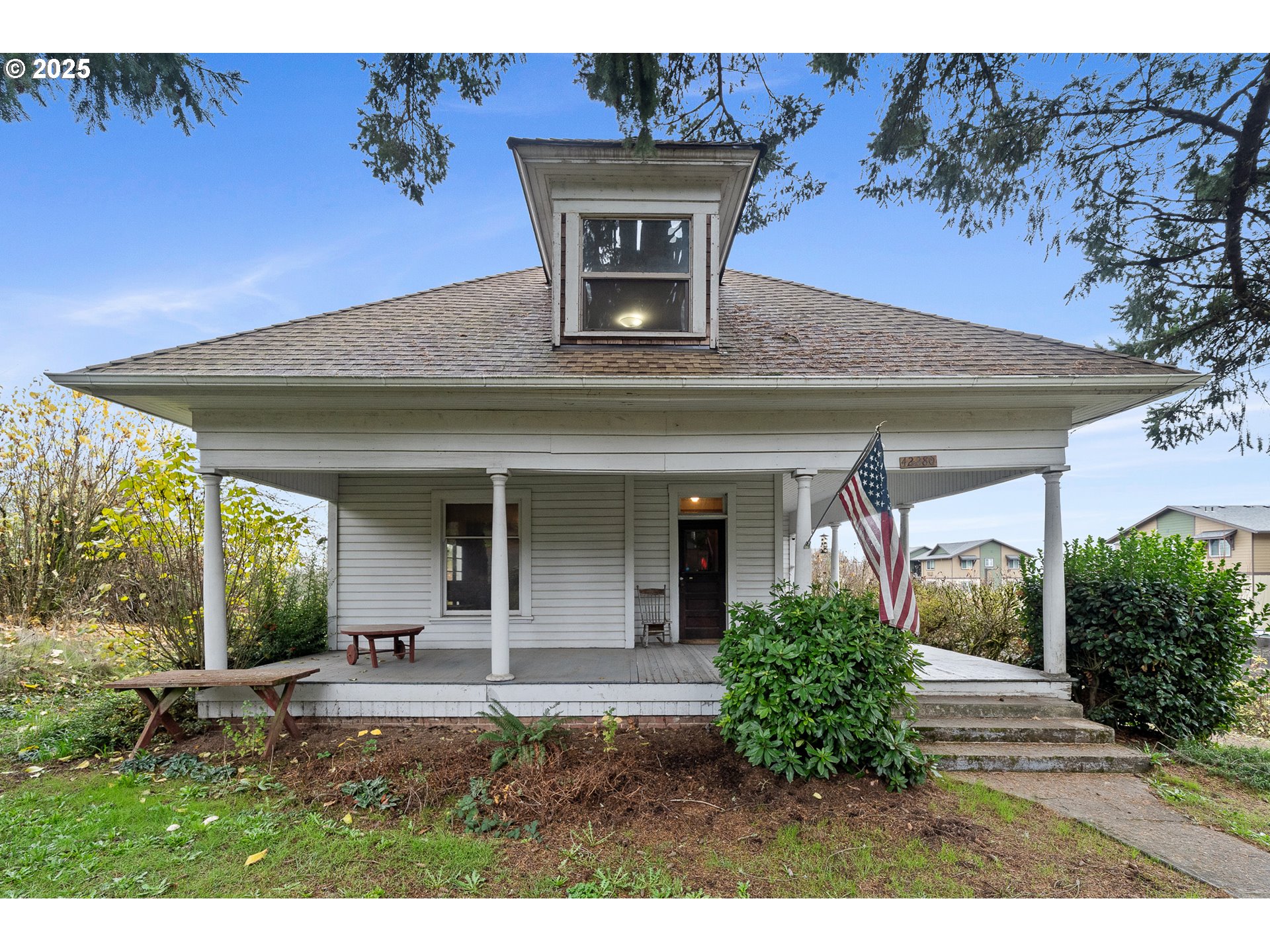 a view of a house with potted plants and a table and chair