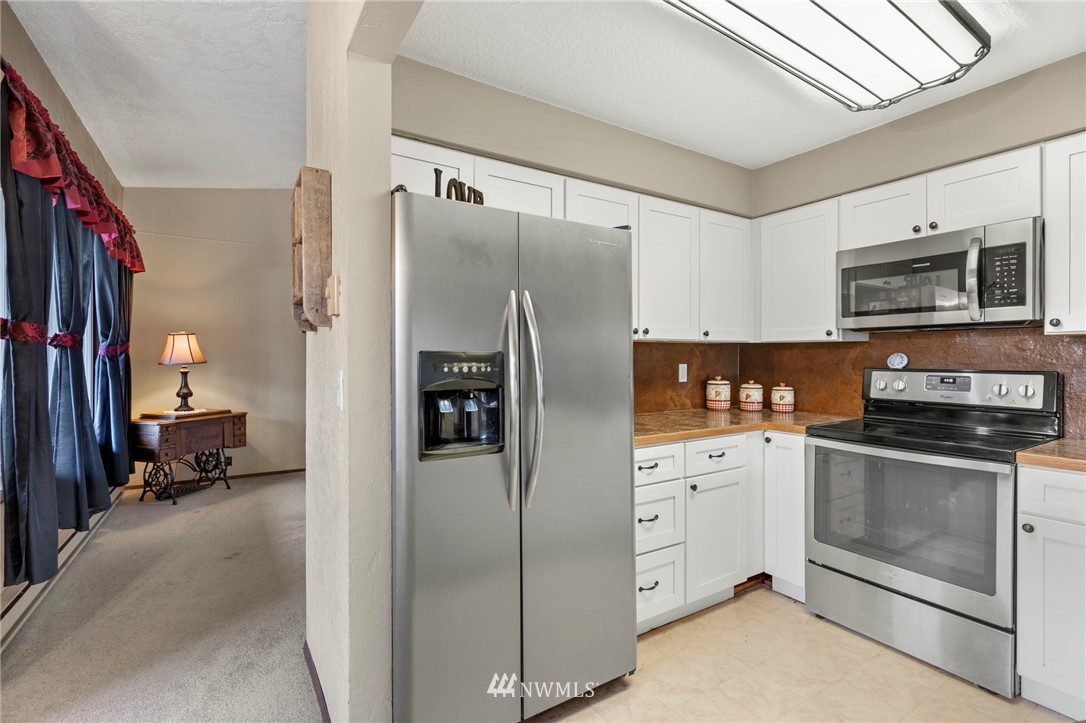 167 Hillcrest Road Chehalis, WA 98532 - Photo 8 of 26 a kitchen with white cabinets and stainless steel appliances