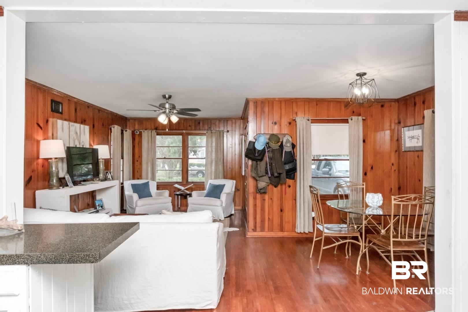 20 Kirby Street Mobile, AL 36607 - Photo 11 of 35 Living room featuring wood walls, ceiling fan with notable chandelier, and hardwood / wood-style flooring