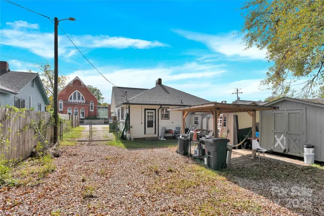a view of a house with a yard and large tree