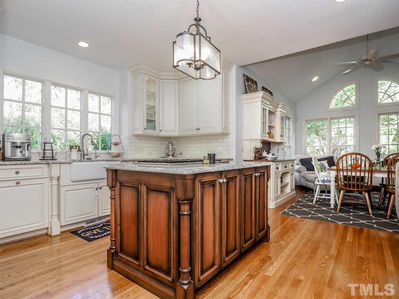 1408 Ridge Side Place Raleigh, NC 27613 - Photo 16 of 25 a open kitchen with stainless steel appliances granite countertop a stove top oven a sink dishwasher and white cabinets with wooden floor