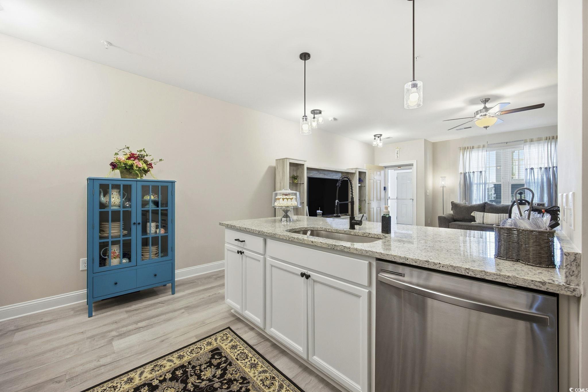 165 Ella Kinley Circle, Unit 302 Myrtle Beach, SC 29588 - Photo 38 of 38 Kitchen with white cabinetry, stainless steel dishwasher, open floor plan, ceiling fan, and light stone countertops