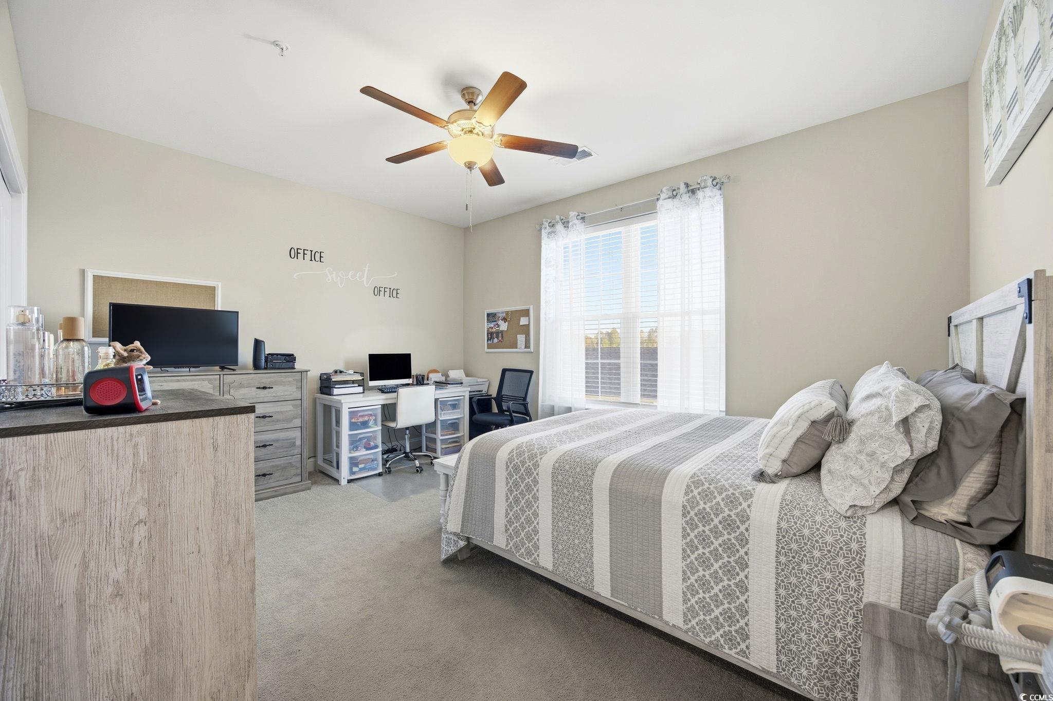 165 Ella Kinley Circle, Unit 302 Myrtle Beach, SC 29588 - Photo 15 of 38 Bedroom with multiple windows, light colored carpet, a ceiling fan, and a desk