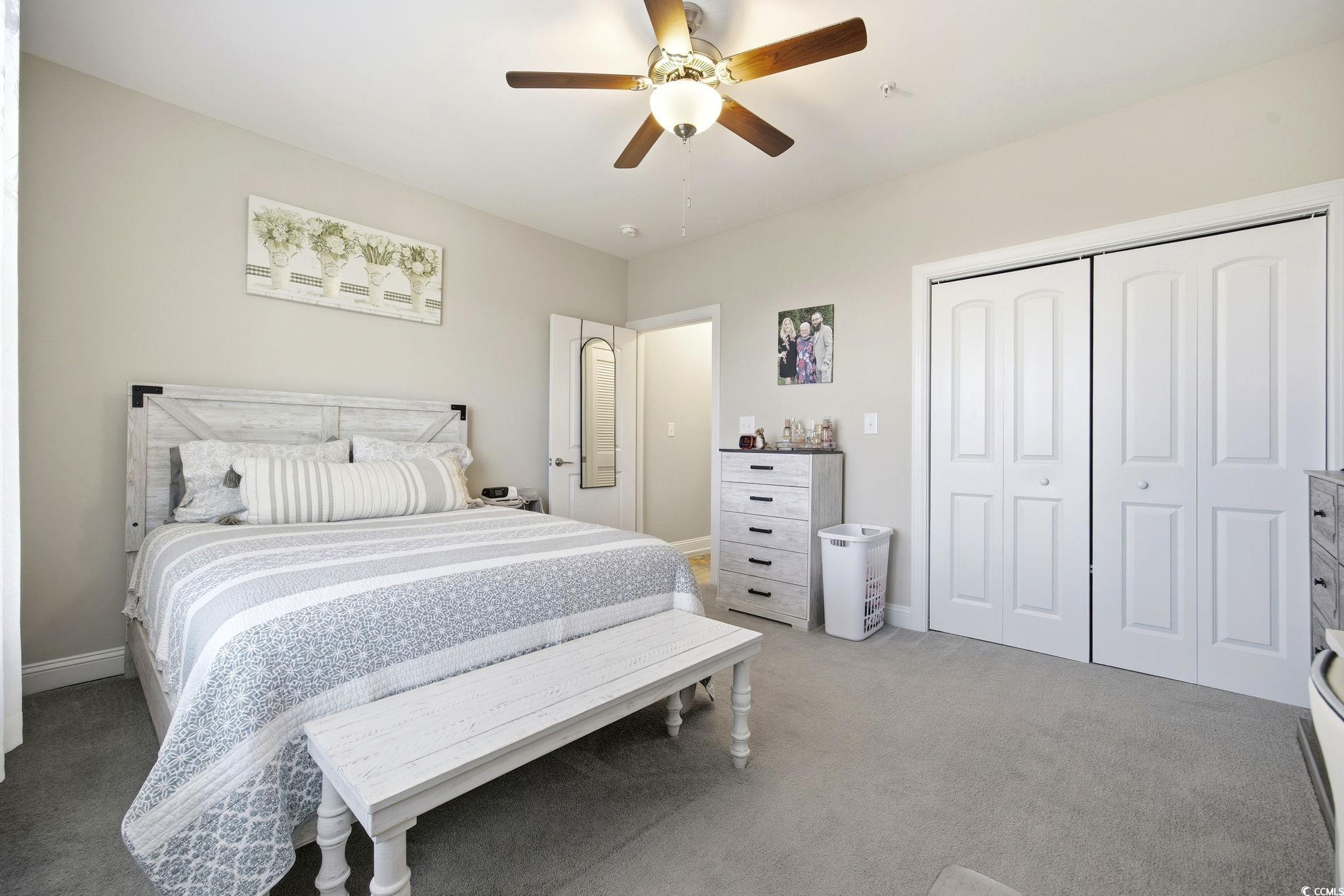 165 Ella Kinley Circle, Unit 302 Myrtle Beach, SC 29588 - Photo 16 of 38 Bedroom with light colored carpet, a ceiling fan, and a closet