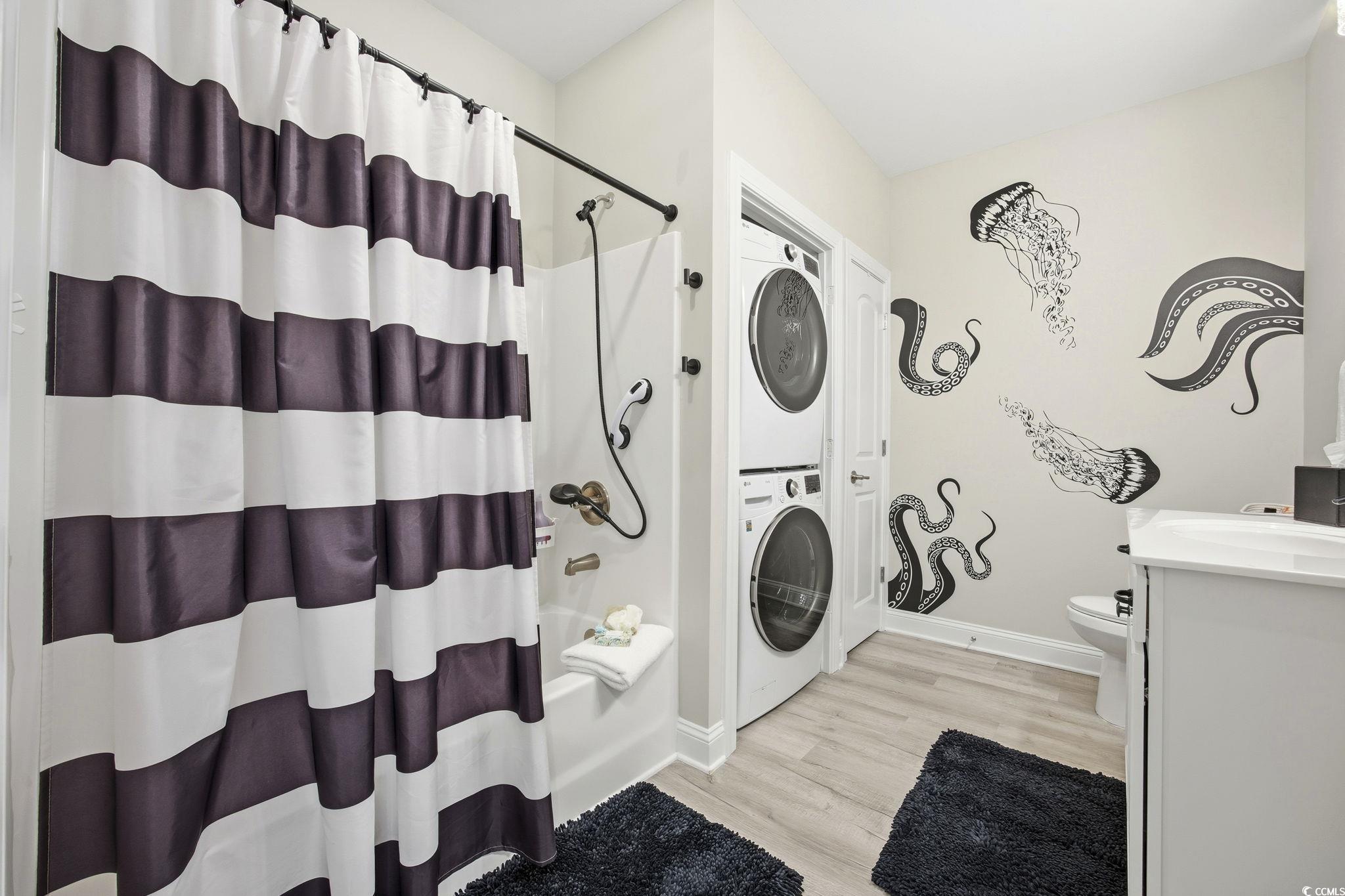 165 Ella Kinley Circle, Unit 302 Myrtle Beach, SC 29588 - Photo 18 of 38 Full bath featuring vanity, stacked washer / dryer, shower / bathtub combination with curtain, and light wood-style floors