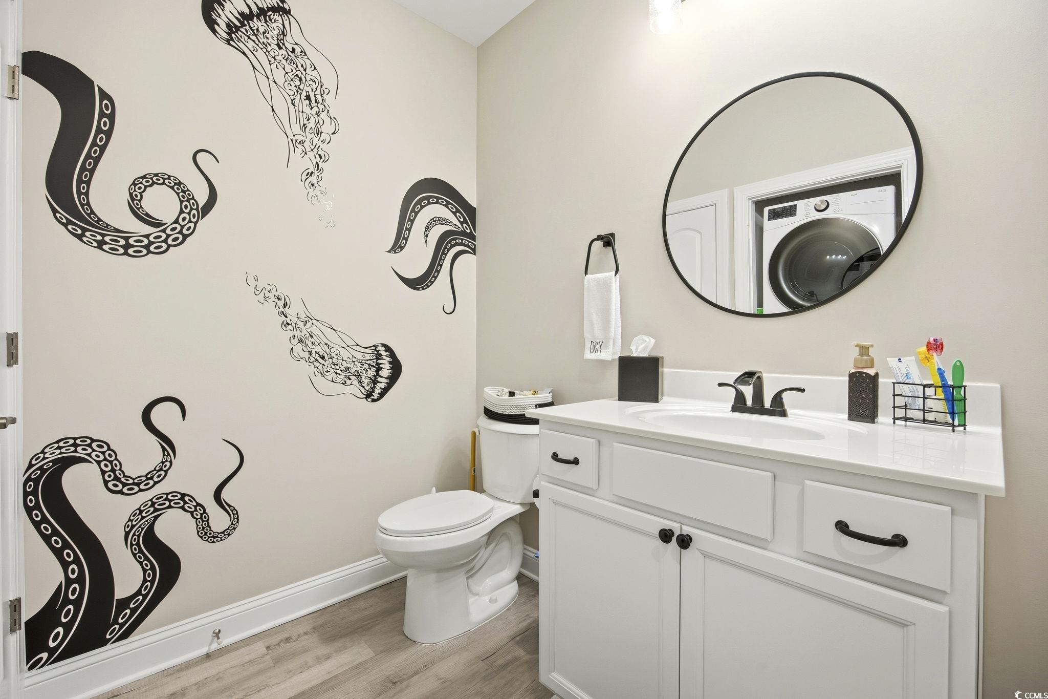165 Ella Kinley Circle, Unit 302 Myrtle Beach, SC 29588 - Photo 19 of 38 Half bathroom featuring vanity, washer / dryer, and light wood-type flooring