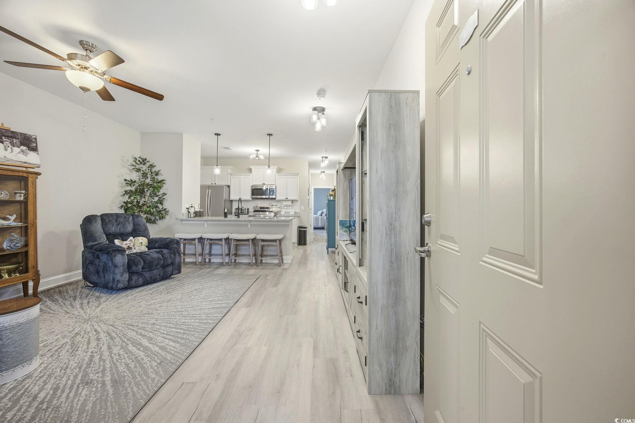 165 Ella Kinley Circle, Unit 302 Myrtle Beach, SC 29588 - Photo 3 of 38 Living room featuring light wood-style flooring and a ceiling fan