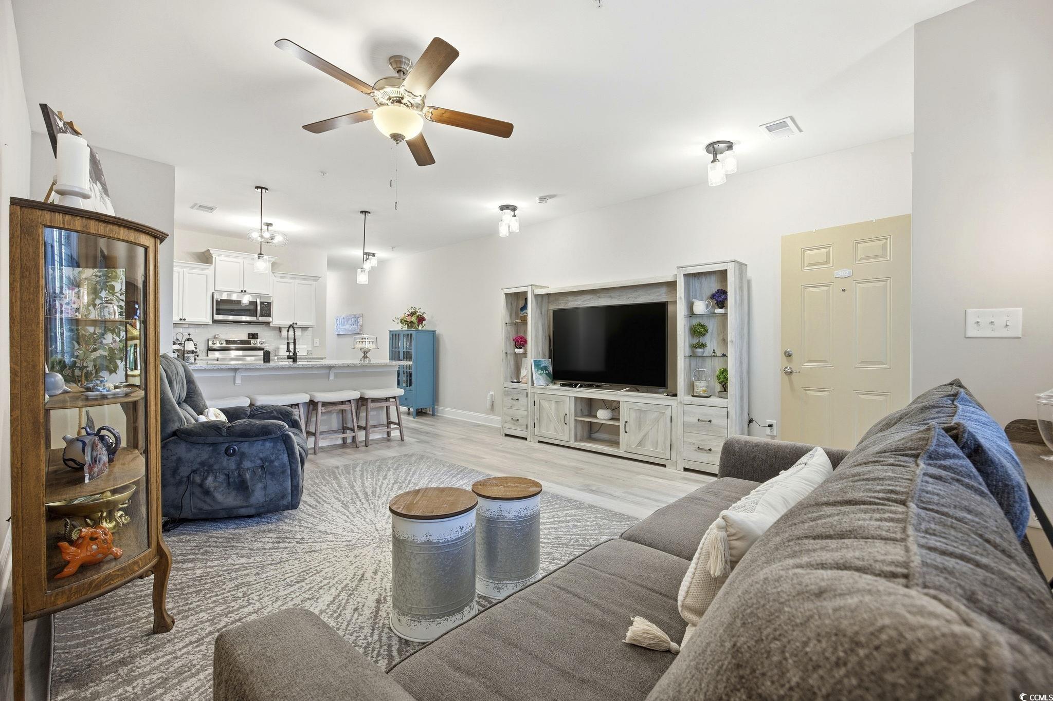 165 Ella Kinley Circle, Unit 302 Myrtle Beach, SC 29588 - Photo 6 of 38 Living room featuring a ceiling fan and light wood-style flooring