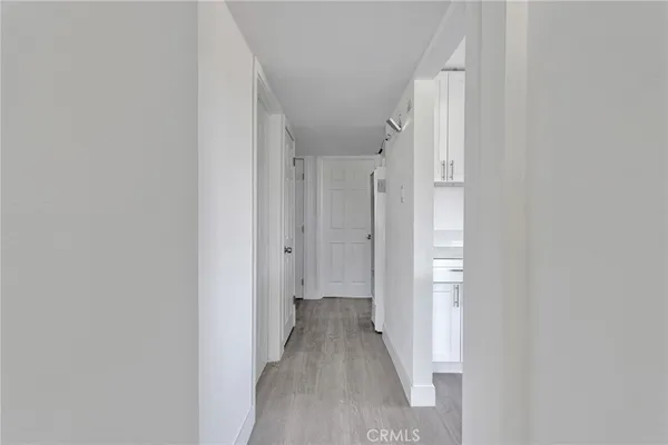 a view of a hallway with wooden floor