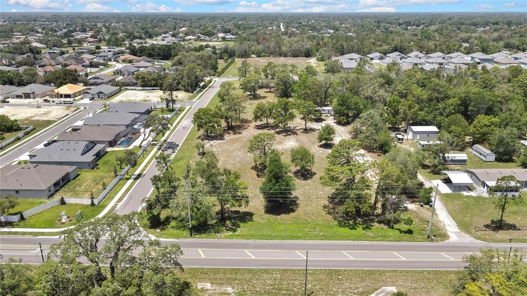 an aerial view of residential houses with outdoor space and trees