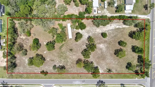 an aerial view of a house with a yard and lake view
