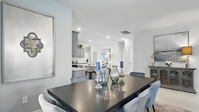 a kitchen with kitchen island a dining table and chairs