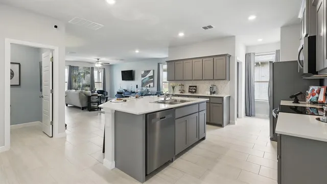 a kitchen with stainless steel appliances kitchen island granite countertop a stove and a sink