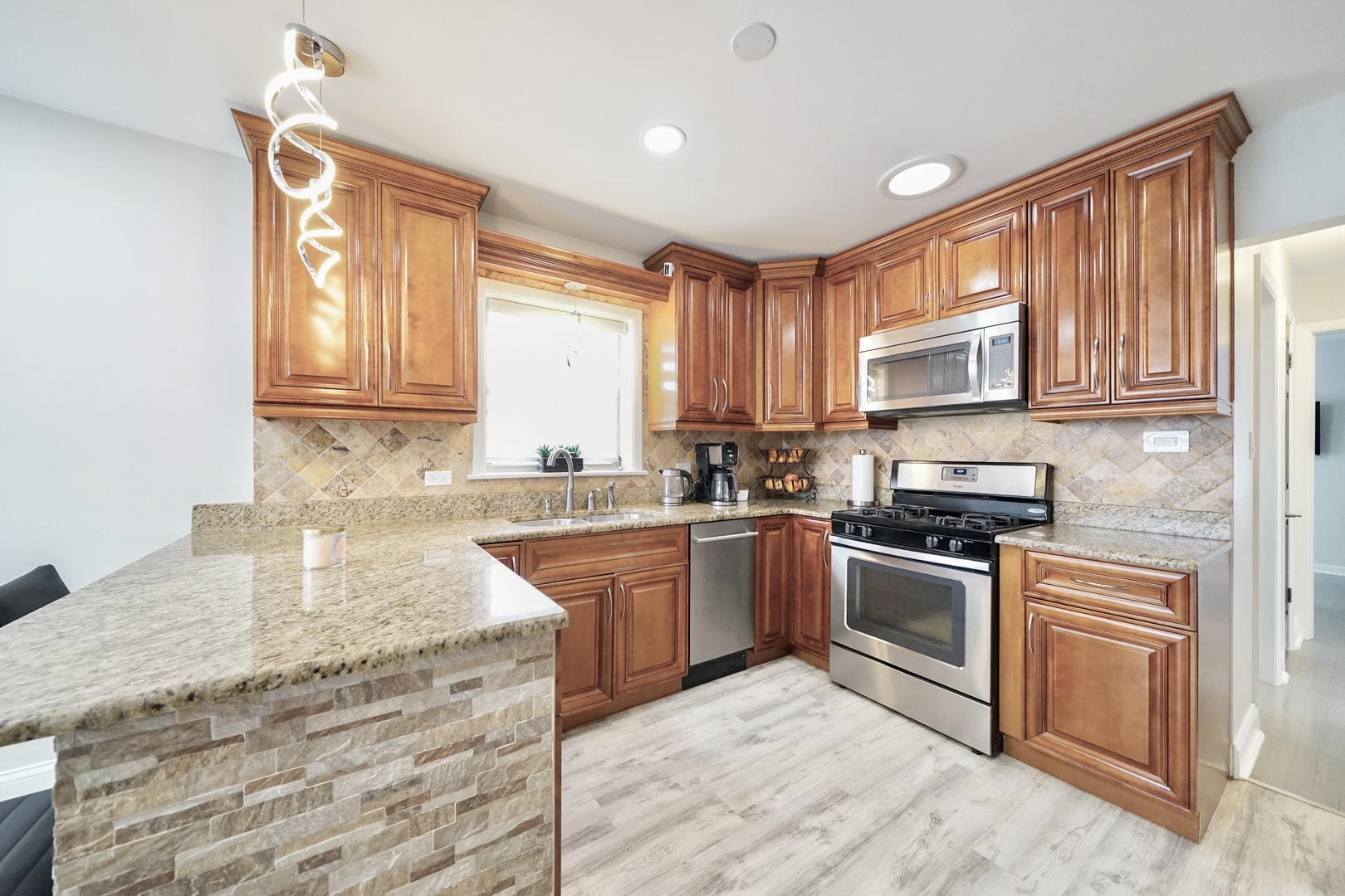 7122 Agatite Avenue Norridge, IL 60706 - Photo 21 of 64 a kitchen with granite countertop a stove sink and cabinets