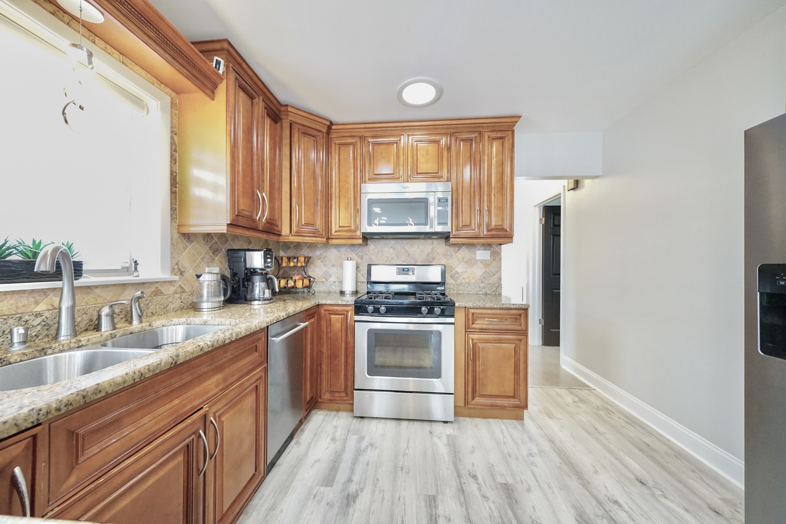 7122 Agatite Avenue Norridge, IL 60706 - Photo 22 of 64 a kitchen with stainless steel appliances granite countertop a stove a sink dishwasher and a refrigerator with wooden floor