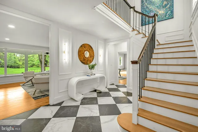 a view of a hallway with wooden floor and a chandelier