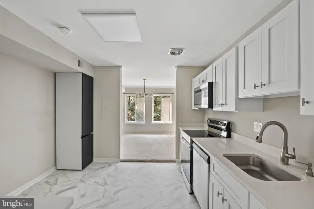 a kitchen with stainless steel appliances granite countertop a sink stove and white cabinets