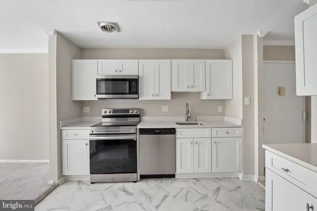 a kitchen with cabinets appliances and a sink