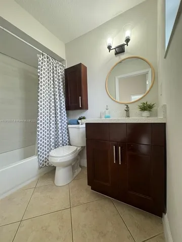 a bathroom with a toilet mirror vanity and a sink