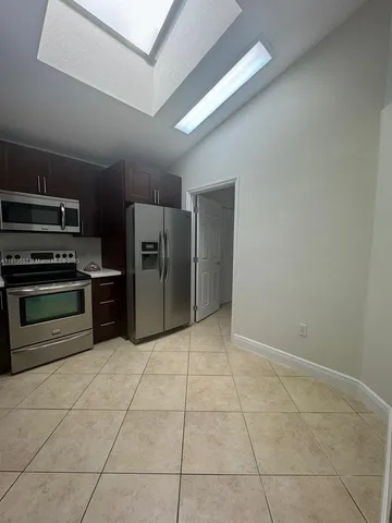 a kitchen with stainless steel appliances a refrigerator and a stove top oven