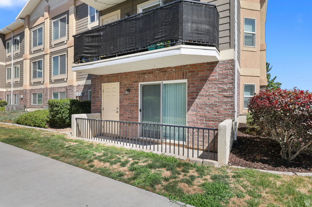 8264 South Resaca Drive, Unit K3 Sandy, UT 84070 - Photo 24 of 30 Ground-level patio entry featuring brick veneer siding and a sliding glass door