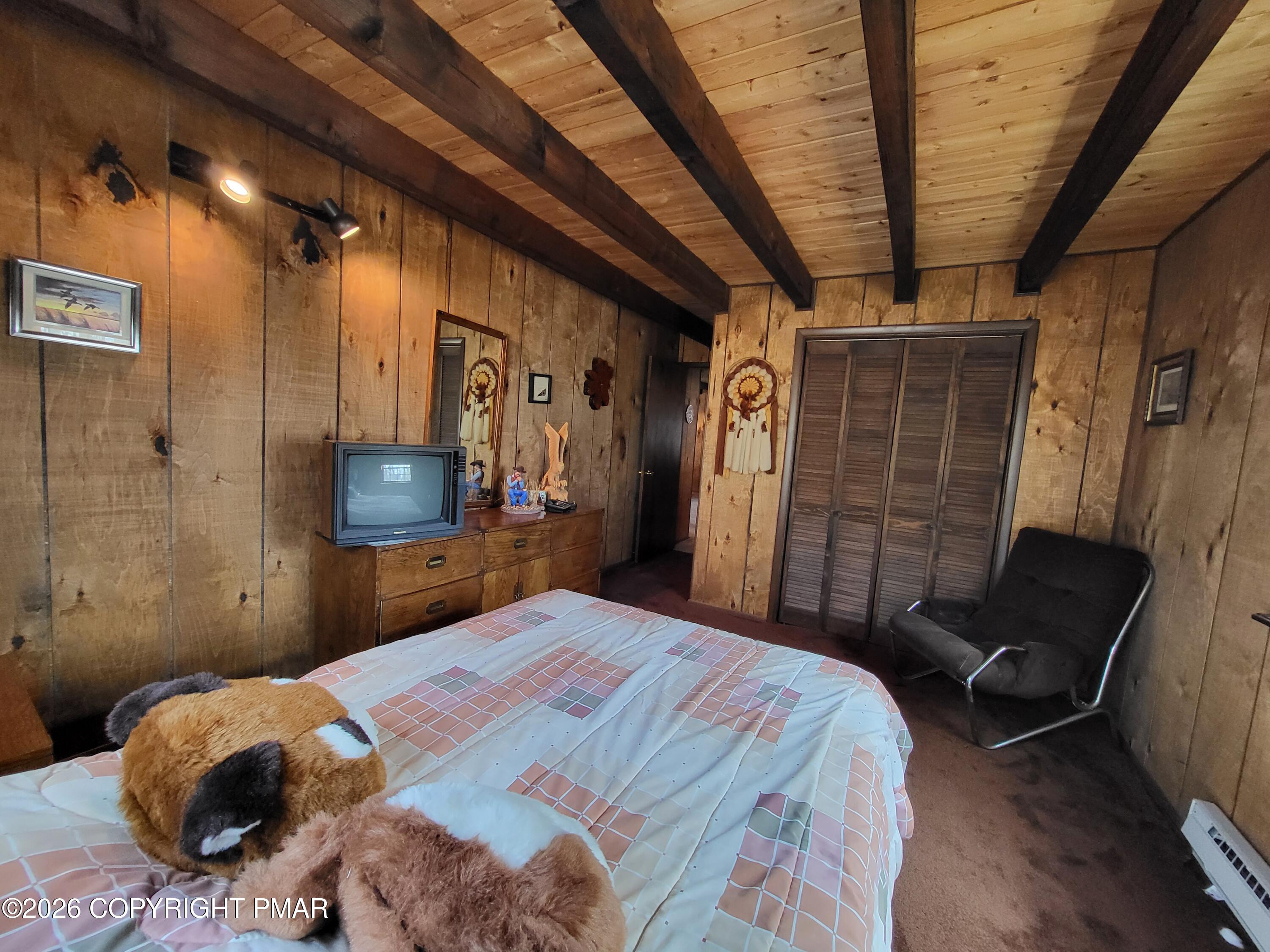 2014 Scarborough Way Bushkill, PA 18324 - Photo 27 of 82 a bedroom with a bed a couch and a flat tv screen