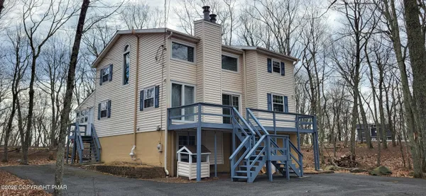 a view of a house with pool lawn chairs and a yard