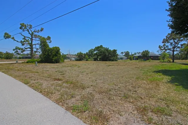 a view of a field with an trees in the background
