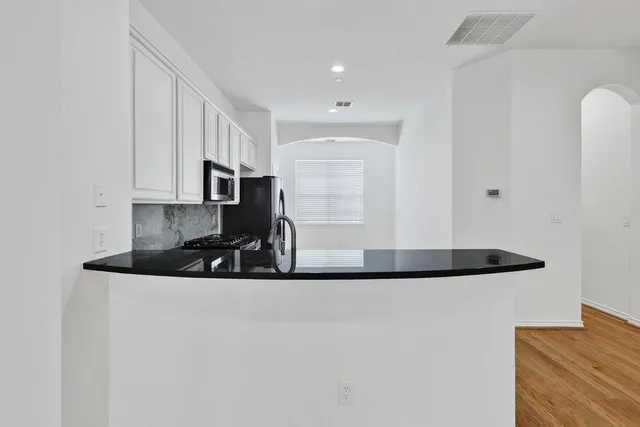 a kitchen with stainless steel appliances granite countertop a sink and a stove