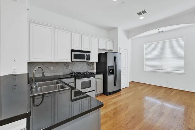a kitchen with stainless steel appliances granite countertop a stove a sink and a refrigerator