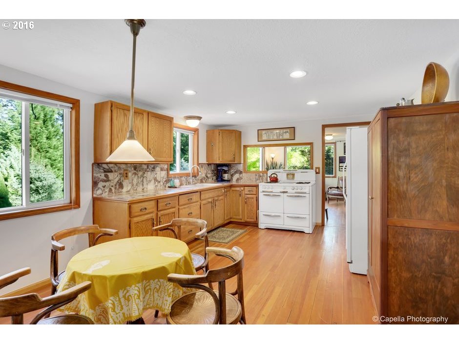 14715 Northwest Newberry Road Portland, OR 97231 - Photo 8 of 32 a kitchen with a table chairs refrigerator and window