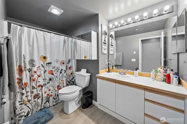 a bathroom with a sink vanity mirror and toilet