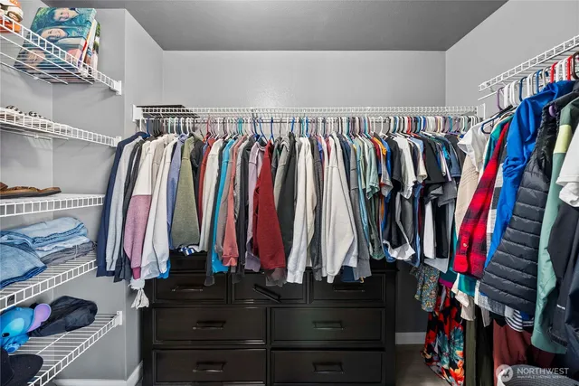 a view of walk in closet with clothes and shoes