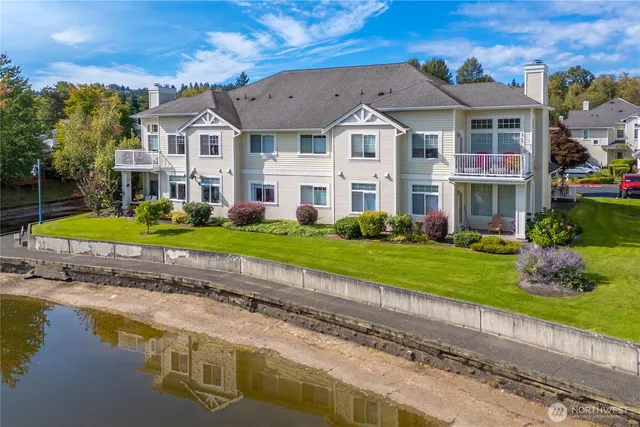 an aerial view of lake and residential houses with outdoor space