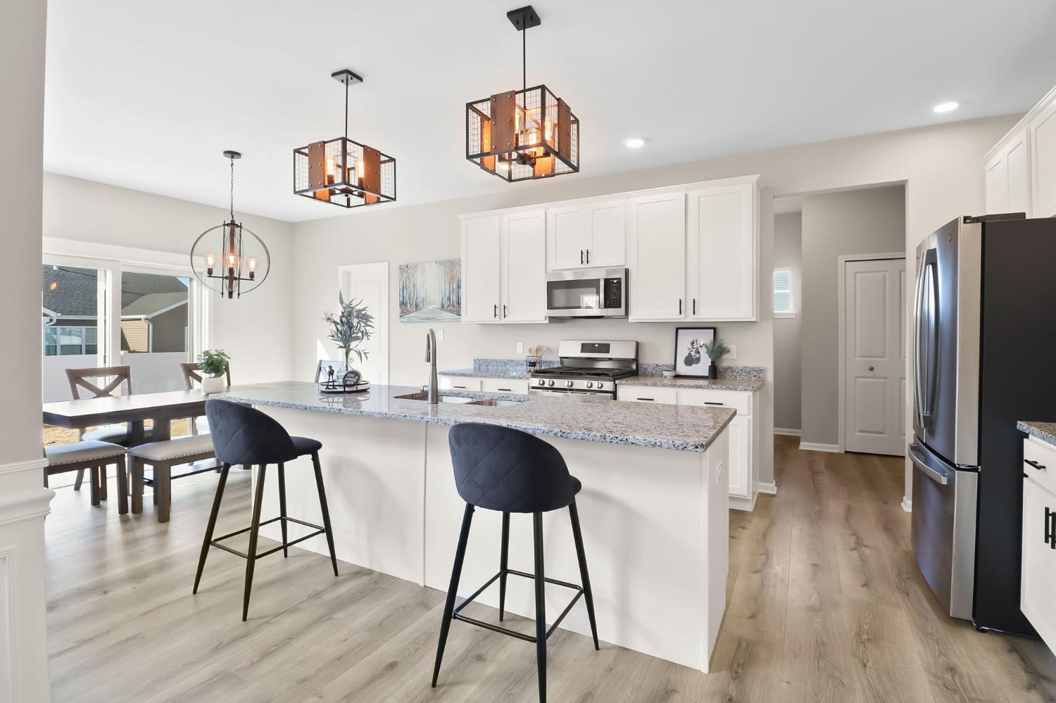 2592 Ritter Street Chesterton, IN 46304 - Photo 7 of 25 a kitchen with stainless steel appliances granite countertop a refrigerator a stove a sink dishwasher a dining table and chairs with wooden floor