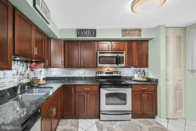 a kitchen with stainless steel appliances granite countertop a stove microwave and sink