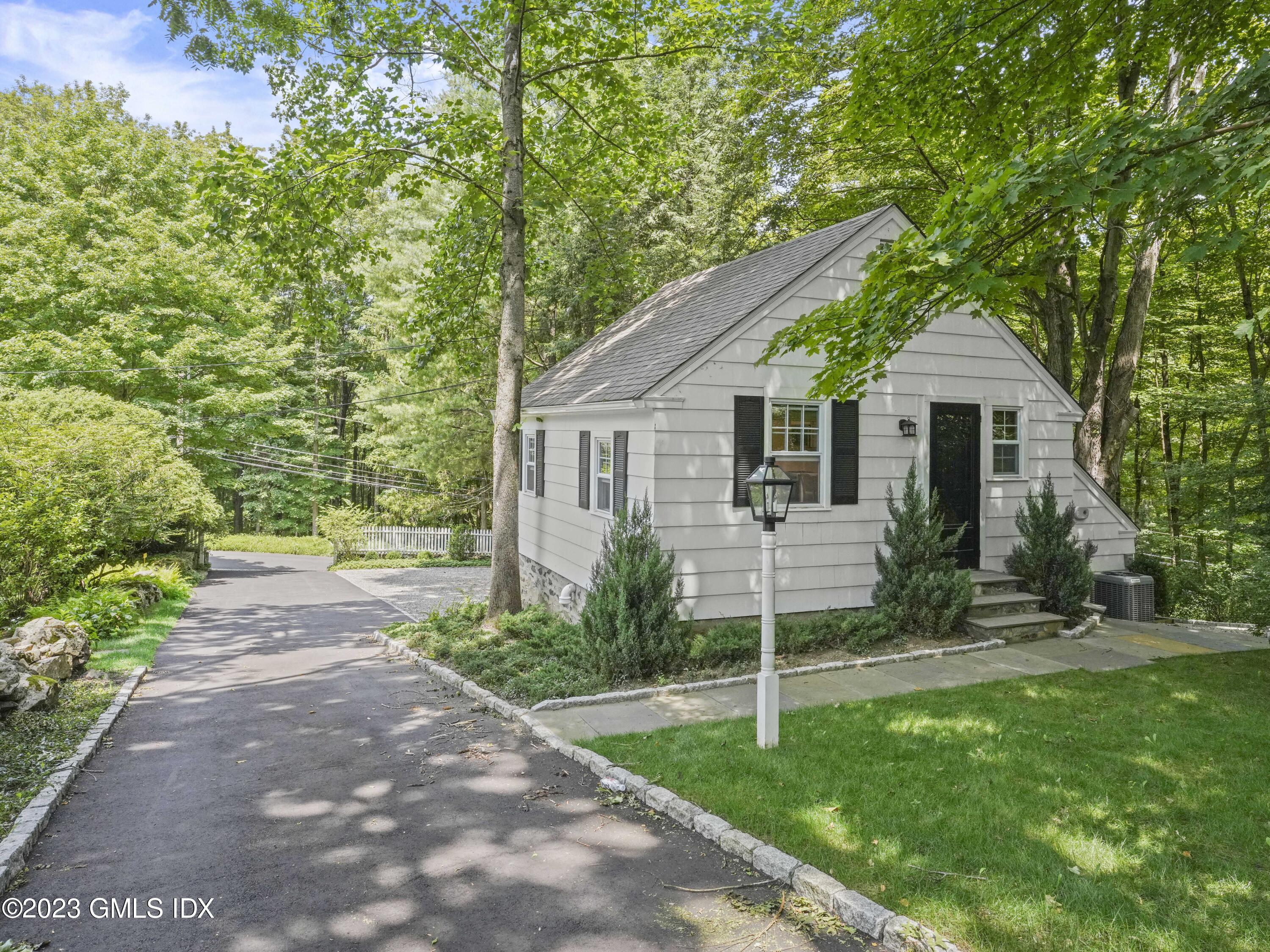 a view of a house with a yard and large tree