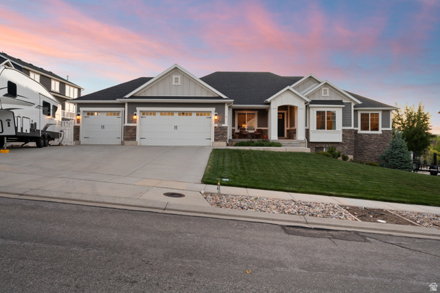 Contemporary ranch-style residence featuring a gray exterior with stone accents and white trim