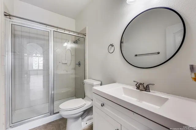 a bathroom with a sink a toilet and a mirror